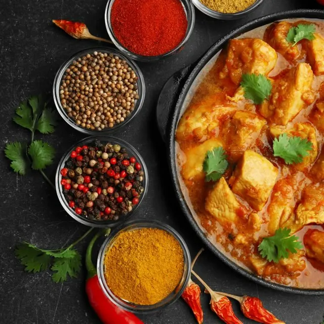 A curry surrounded by whole and ground spices