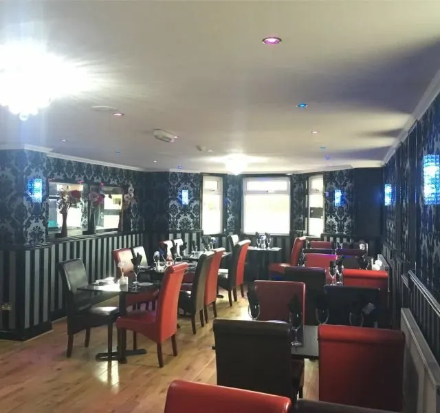 The dining room, with patterned walls and warm wooden floors