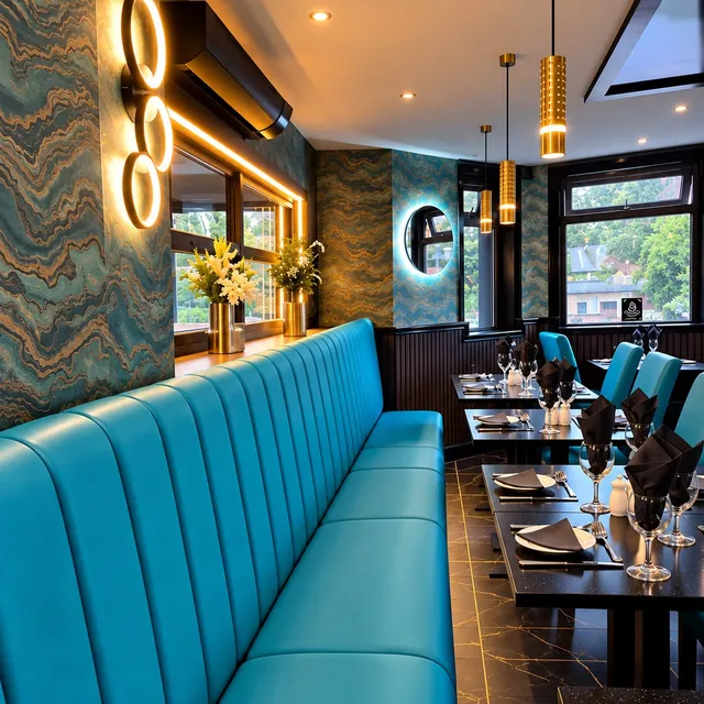 Teal banquette seating beneath gold ring wall lights