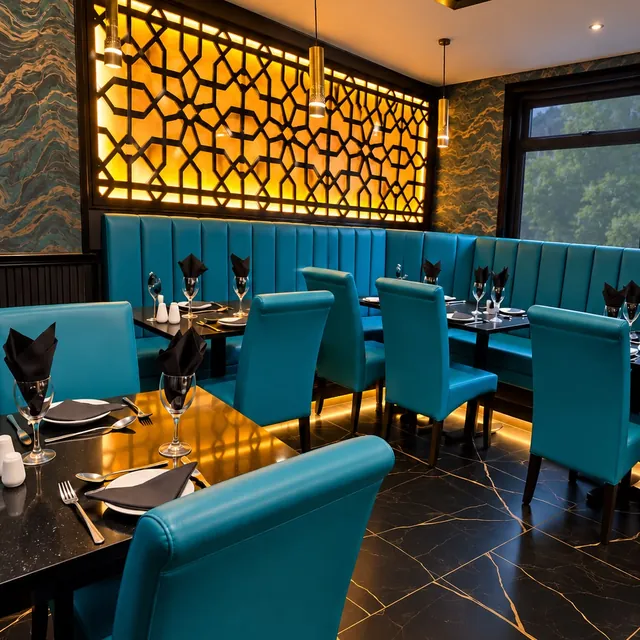 Teal booths beneath a glowing gold lattice screen