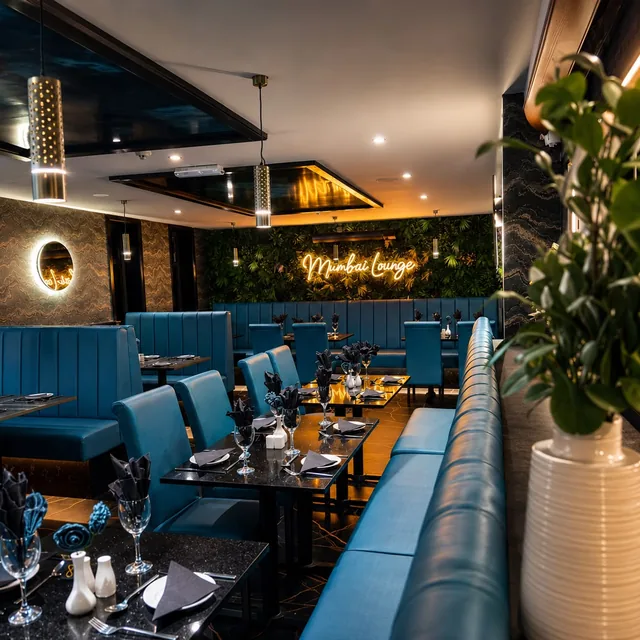 The Mumbai Lounge dining room, with the neon sign and living green wall