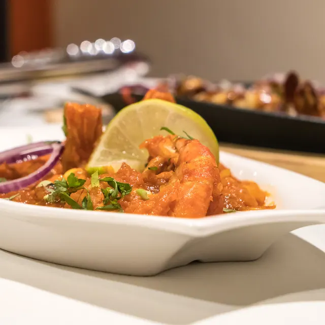King prawns plated with fresh garnish and lemon