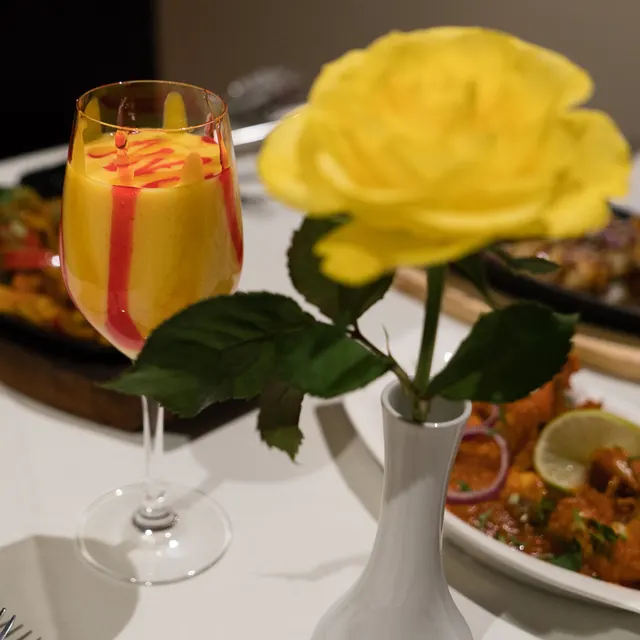 A sizzling tandoori platter served with a drink at the table