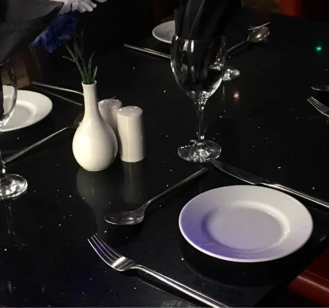 A table laid with glassware and cutlery, ready for service